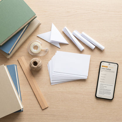 Index cards, tape, string, a ruler and books for the Design Challenge, with the activity on a phone