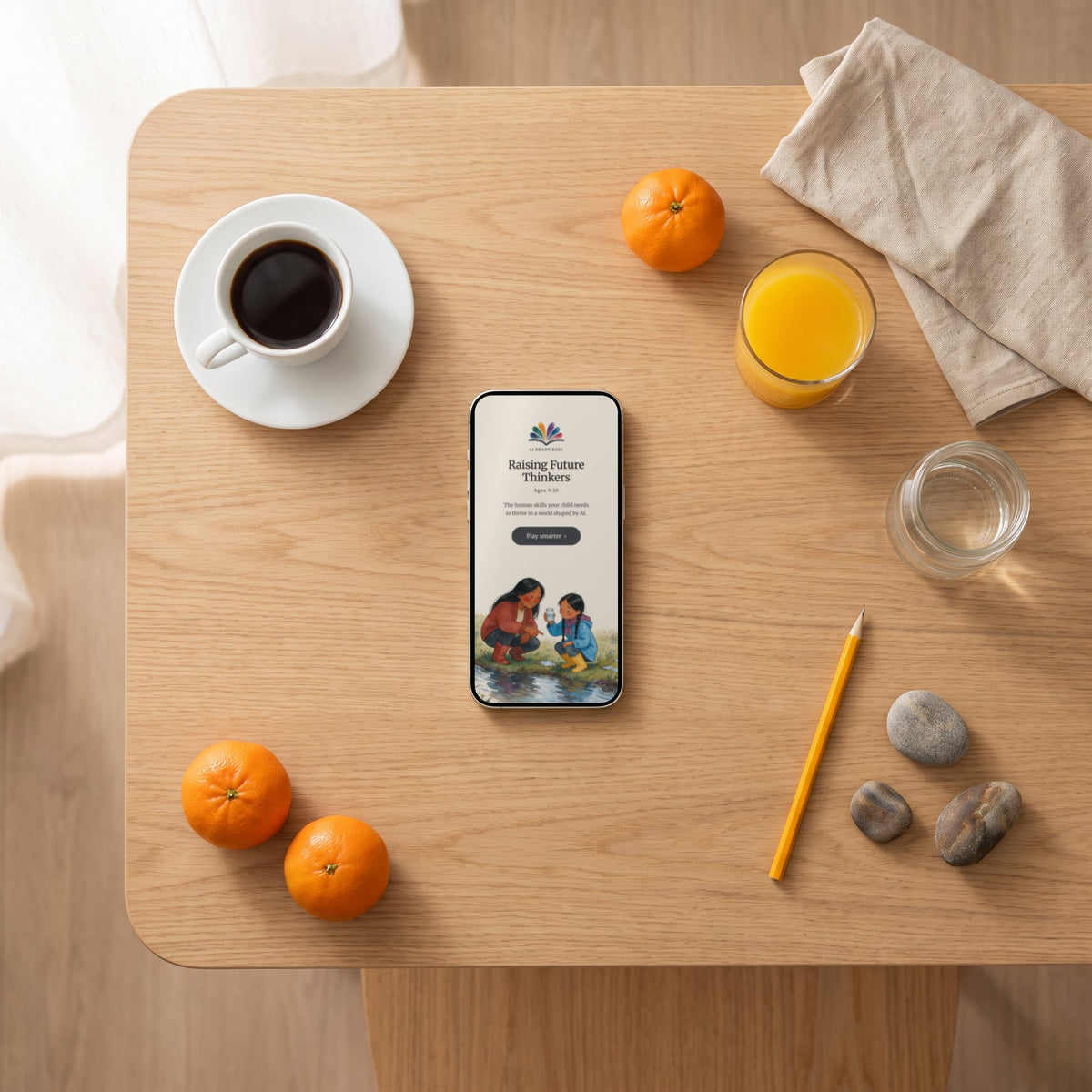 The Raising Future Thinkers ages 9–10 guide open on a phone on a breakfast table